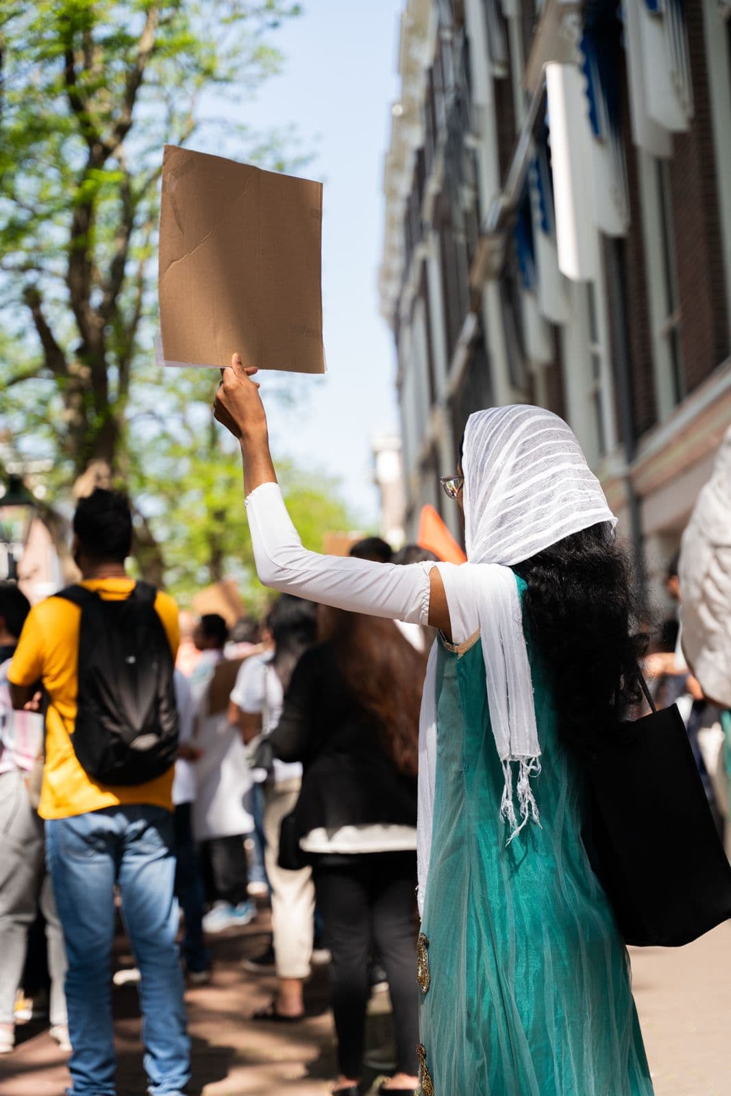 A woman holding up a protest sign at a demonstration